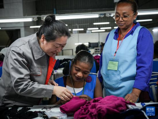 3月28日,在马达加斯加塔那那利佛的内蒙古鹿王羊绒有限公司马达加斯加工厂,一名中方人员为当地工人进行技术指导。新华社记者 李亚辉 摄